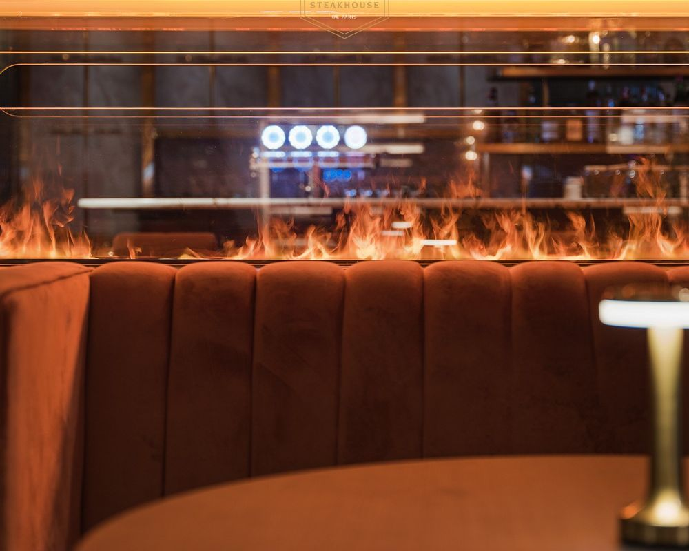Thi công lò sưởi điện hơi nước HK-1500 tại nhà hàng Steakhouse de Paris Chú thích: Không gian lãng mạn và ấm cúng tại Steakhouse de Paris dưới ánh lửa 4D rực rỡ